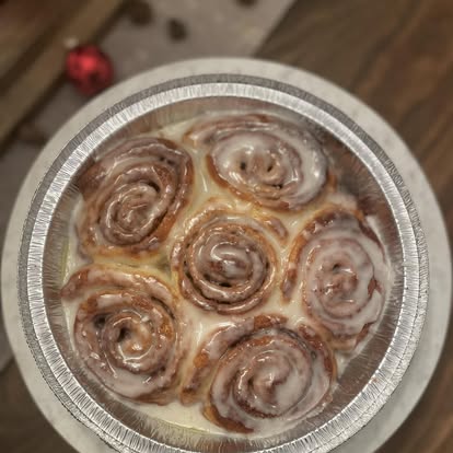 Cinnamon rolls with sugar icing in a foil pan